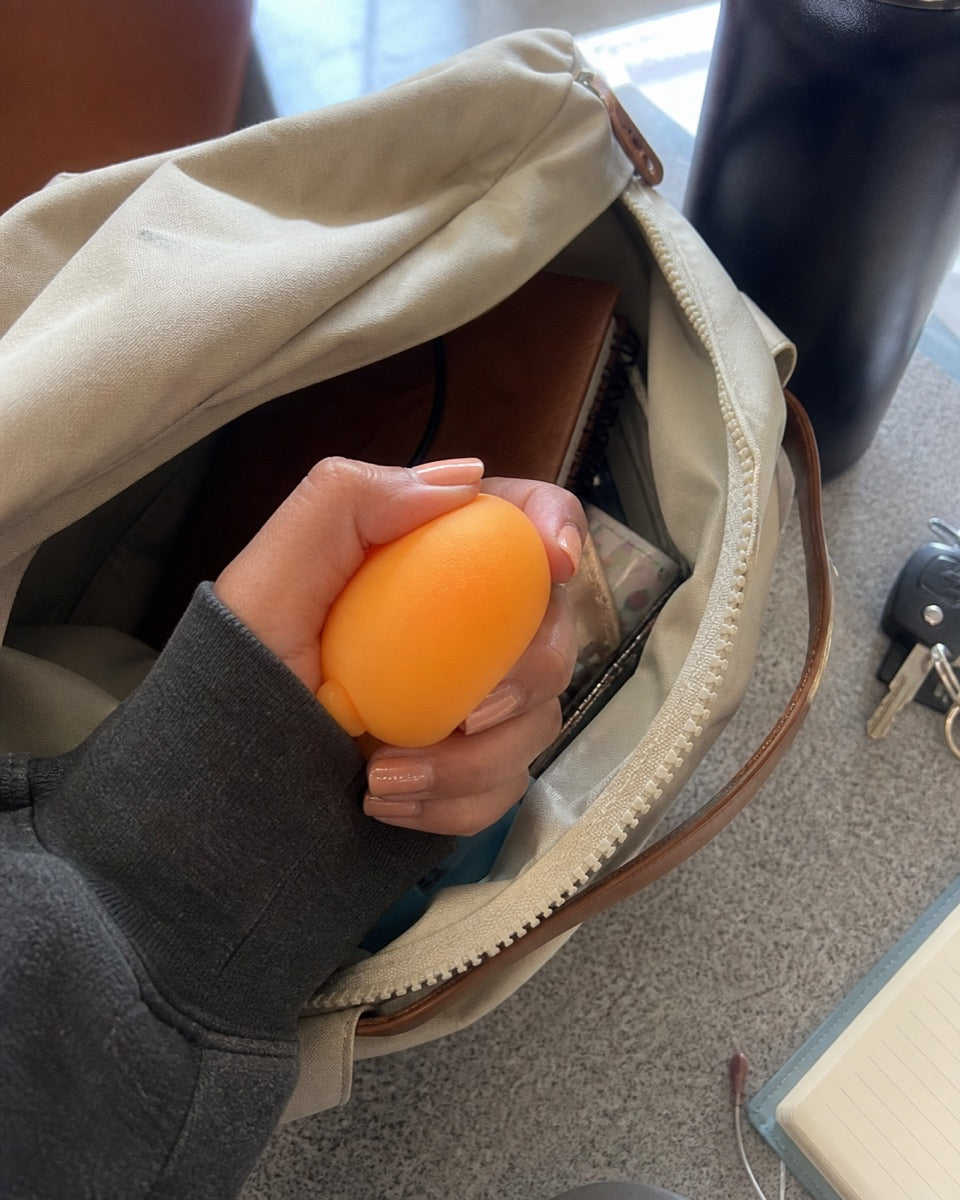 An orange sensory toy beside an open bag